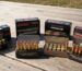 A variety of ammunition types laid out on a shooting range table, highlighting quality and affordability